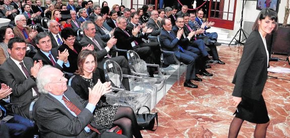 La diputada socialista María González Veracruz accede a la tribuna en el patio del Casino de Murcia. En primer término, el expresidente Carlos Collado, aplaudiéndole.
