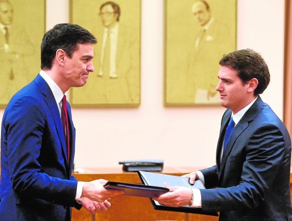 Pedro Sánchez y Albert Rivera intercambian el documento firmado ayer en Madrid de cara a una hipotética investidura del líder socialista.