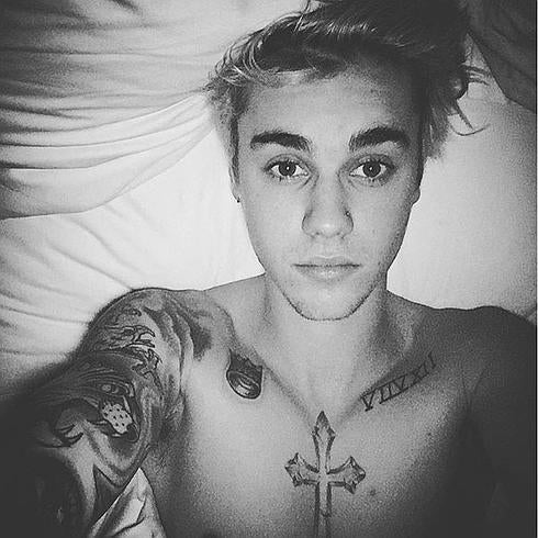 Justn Bieber enseña su piercing desde su cama.