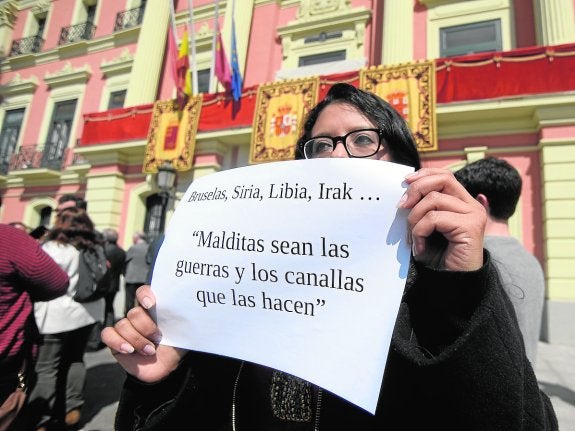 Una joven muestra un cartel durante la concentración junto al Ayuntamiento de Murcia.