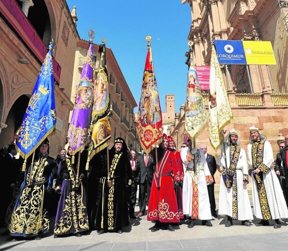 Los abanderados, con las enseñas de las cofradías, durante la convocatoria en la plaza de España.