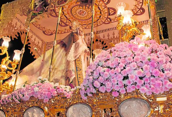 La Santísima Virgen de la Amargura, en su trono de estilo barroco, con los misterios del rosario en marfil y rodeada por claveles de color rosa. :: javier carrión / agm
