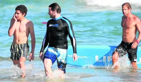 Jackman sale del agua junto a su hijo Oscar. 