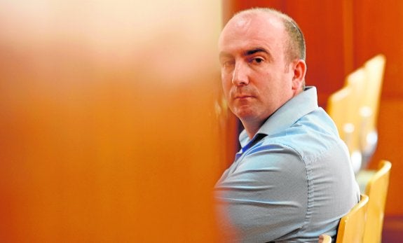 Roberto Peñuelas mira a través de la puerta entreabierta de la sala de la Audiencia.