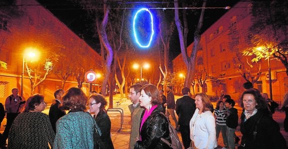 Asistentes al proyecto 'Luz' pasan, anoche, junto a una de las creaciones lumínicas que cuelgan en una de las zonas peatonales de Vistabella.