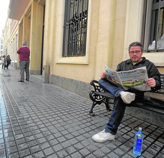 Eugenio Ayala lee 'La Verdad' sentado en un banco, en la puerta de San Miguel.