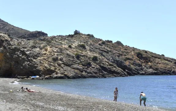 Bañistas, ayer por la mañana en la playa de El Portús. Al fondo, el monte que hay que atravesar para llegar a la zona nudista. 