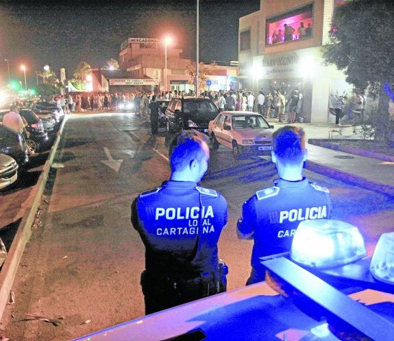 Dos agentes vigilan una concentración de jóvenes junto al centro comercia del Mercadona, en una imagen de archivo.