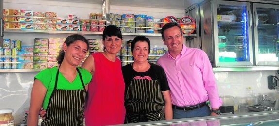 María González Veracruz, ayer, con el alcalde de Alhama, Diego Conesa, y las vendedoras de un puesto del mercadillo. :: psoe
