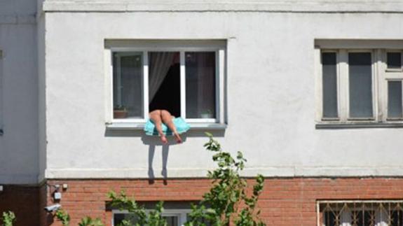 Una mujer tomando el sol en una ventana irrita a sus vecinos