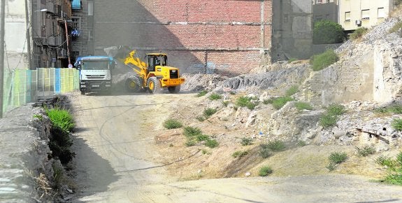 Una pala y un camión, durante la limpieza de un solar municipal en la Morería Baja.