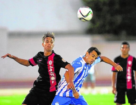 Miguel Guirao, con la camiseta del Almería B, pugna con un jugador del Jumilla. 