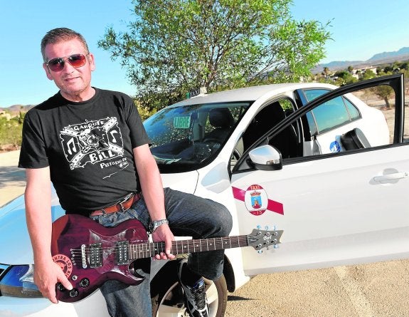 Rufino Martínez, guitarra en mano, y junto a su taxi. 