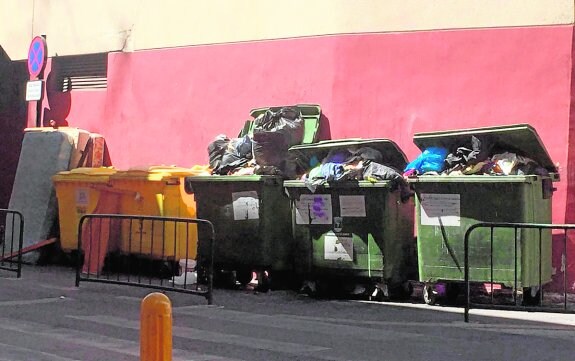 Varios contenedores repletos de basura, en una céntrica calle de la localidad. 