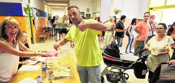 Un padre deposita su voto ayer en el colegio El Palmeral de Alicante, que eligió la jornada continua.