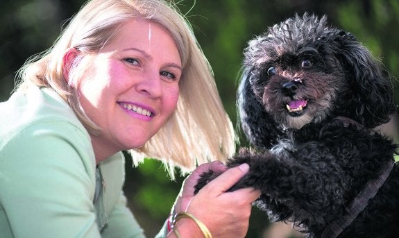 Silvia Barquero, con la perrita 'Tarifa', que cuida su familia tras encontrarla abandonada durante unas vacaciones en la costa gaditana.  