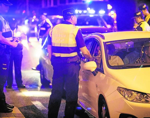 Un policía frente a un coche en el control montado la madrugada del sábado en la avenida Miguel Indurain. 