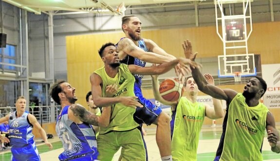 Olaizola, en el centro, pugna por el balón con varios rivales en un partido de pretemporada entre el GBC y el Calzados Robusta.