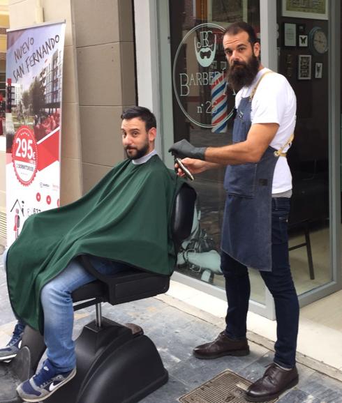 La barbería de la calle Lope Gisbert tuvo que trasladar su negocio a la calle por el apagón. 
