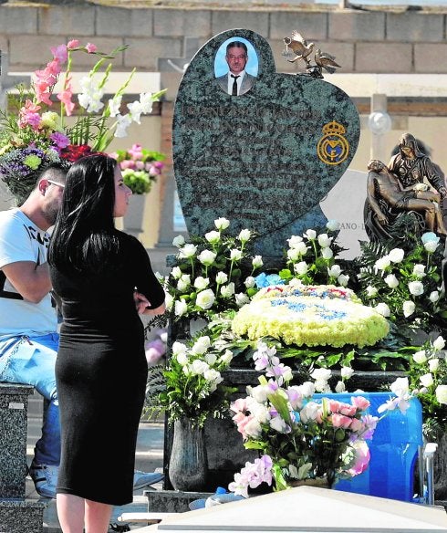 Rosas blancas y corona de flores con el escudo del Real Madrid en la tumba de un difunto aficionado en Nuestro Padre Jesús. 