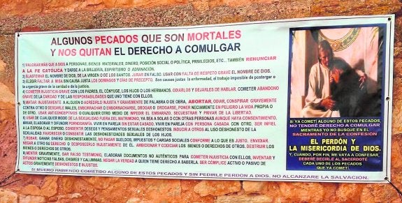 Pancarta colgada en la fachada de la iglesia por el párroco de Viveros (Albacete), con la lista de pecados.