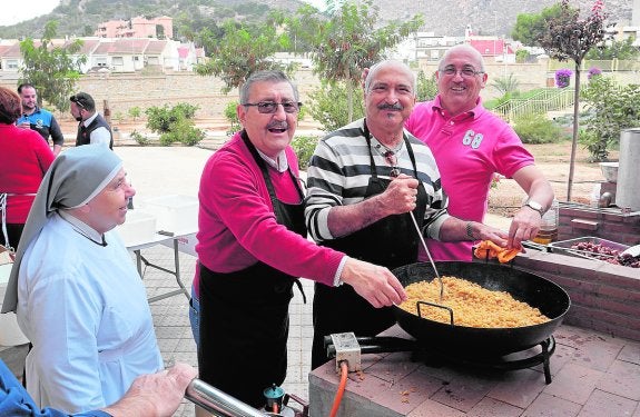 Participantes en las convivencias preparando una paella. 