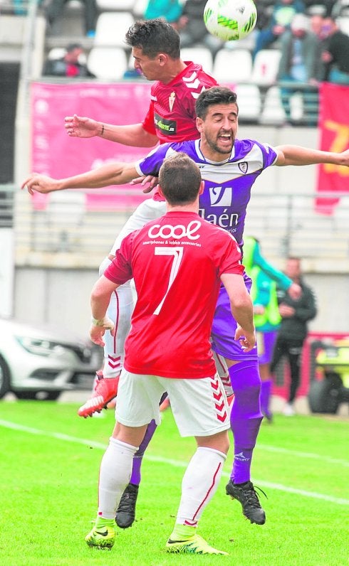 Armando e Isi luchan con un rival del Jaén. 