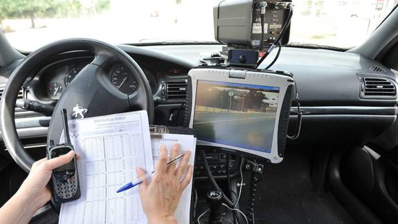 Una agente controla por ordenador la velocidad en una vía de Murcia desde el interior del coche camuflado.