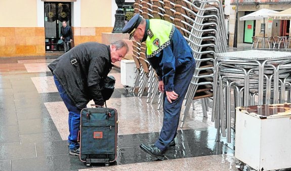 Policías inspeccionando la maleta sospechosa, ayer.