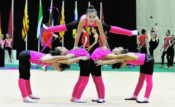 Imágenes de gimnastas entrenando, ayer, en el Palacio de los Deportes de Murcia, en la jornada previa al inicio del Nacional de conjuntos.