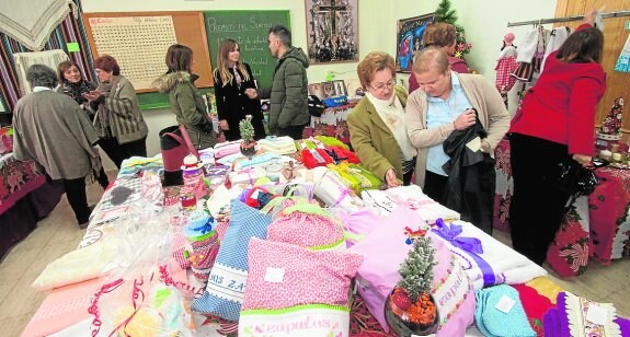 Cojines, toallas, adornos y ropa infantil en el mercadillo solidario de Los Garres. 