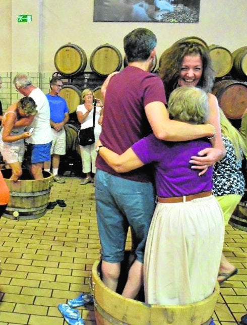 Un grupo de turistas pisan uva en una visita a Bodegas Luzón. 