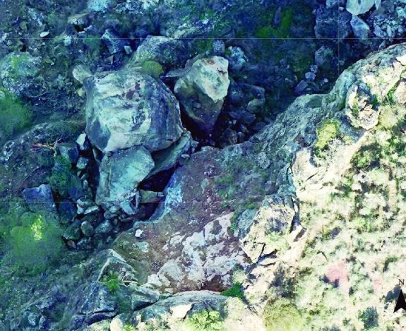 Imagen captada por el dron utilizado la semana pasada en la que se ve la gran roca encallada tras desencajarse de la ladera por las lluvias.