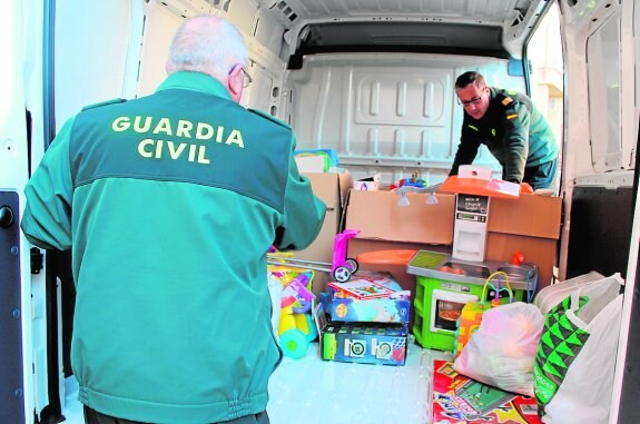 Dos agentes cargan una furgoneta con los juguetes para su traslado a Cáritas.
