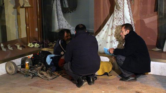 Trabajadores del SEMAS charlando con un mendigo durante una ola de frío en Murcia.