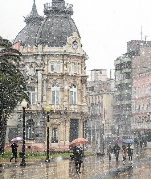 Transeúntes por la plaza de los Héroes de Cavite, con el Ayuntamiento al fondo.