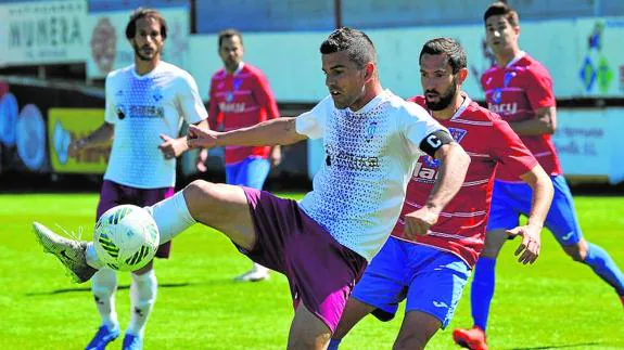 Perona controla el balón, acosado por un jugador de La Roda. 