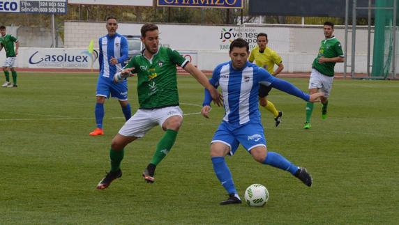 Rojas va a despejar el balón ante la presión de un jugador rival. 