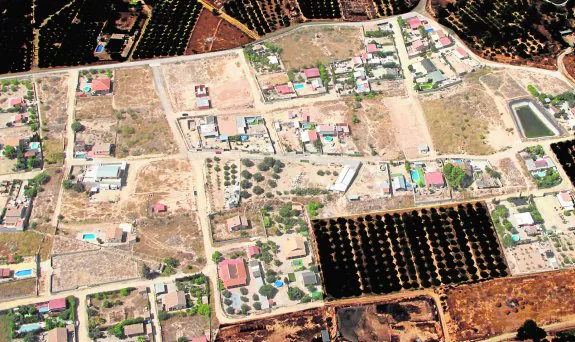 Vista aérea de la urbanización supuestamente ilegal (en tono más claro), con múltiples parcelas construidas.