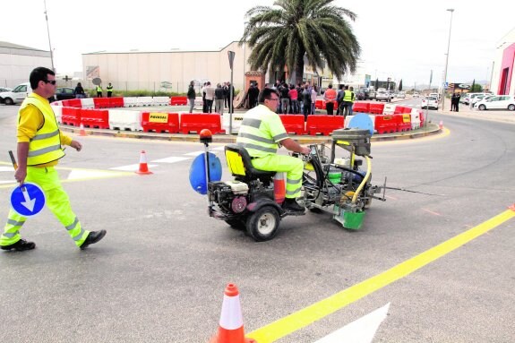 Dos operarios trabajan en la señalización de las obras de la glorieta, en La Palma.
