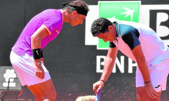 Rafa Nadal se preocupa por la lesión que sufrió el murciano Nico Almagro, ayer. 