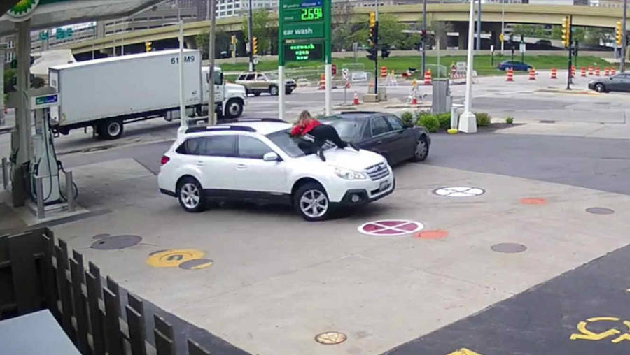 Una mujer salta sobre el capó de su coche para evitar que se lo roben