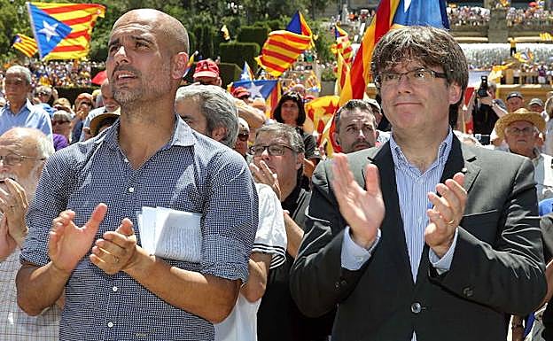 Guardiola (i) y Puigdemont aplauden. 