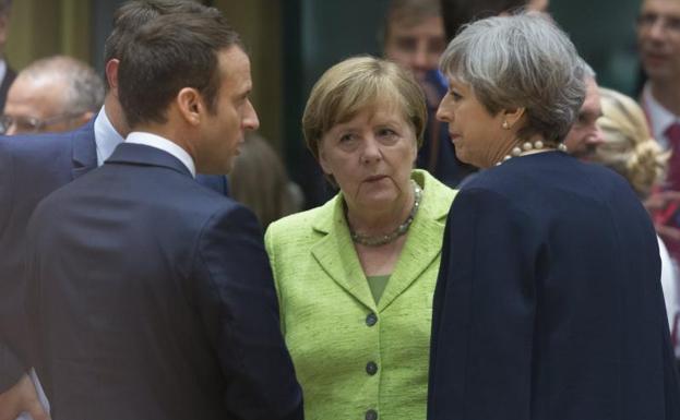 Angela Merkel conversa con Emmanuel Macron y Theresa May.