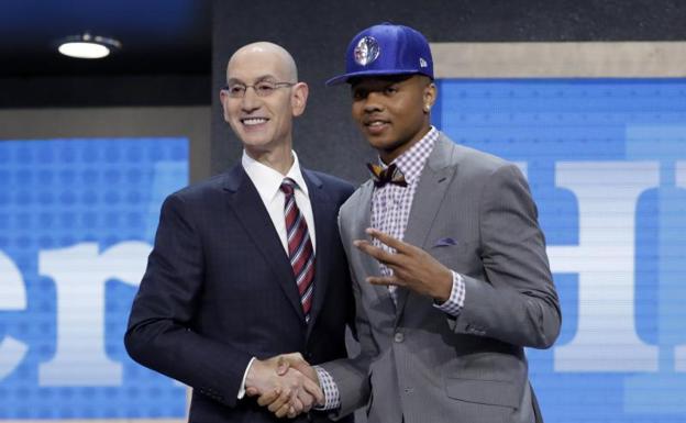 El comisionado de la NBA Adam Silver (i) posa con Markelle Fultz.