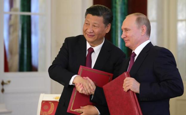 El presidente ruso Vladímir Putin (d) y su homólogo chino Xi Jinping.