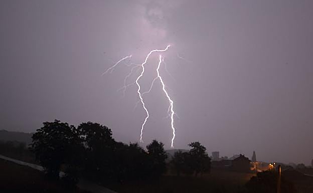Un rayo impacta contra una zona arbolada.
