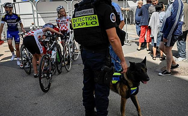 Un policía, acompañado de un perro detector de explosivos, vigila durante la tercera etapa. 