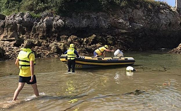 Voluntarios de la DYA trasladan el cadáver hasta el puerto. 
