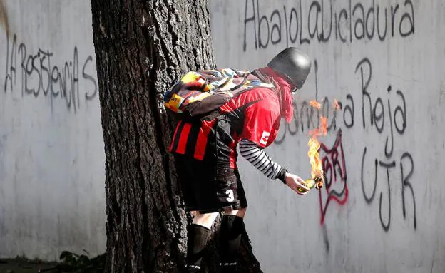 Un manifestante sostiene un cócktel molotov. 